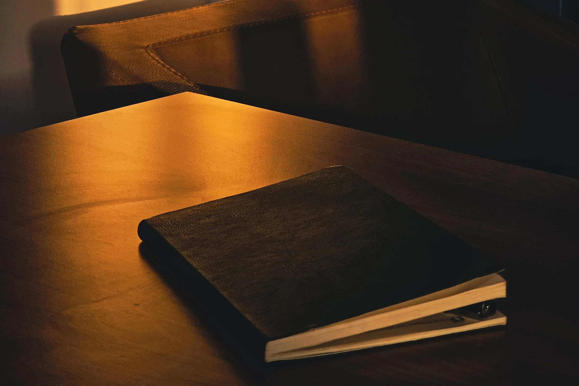 A closed notebook on a quiet desk in soft morning light